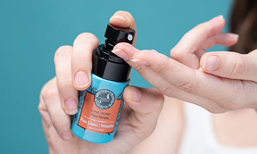 imgae showing a woman taking a small amount of Firm-Focus Face Serum on her finger