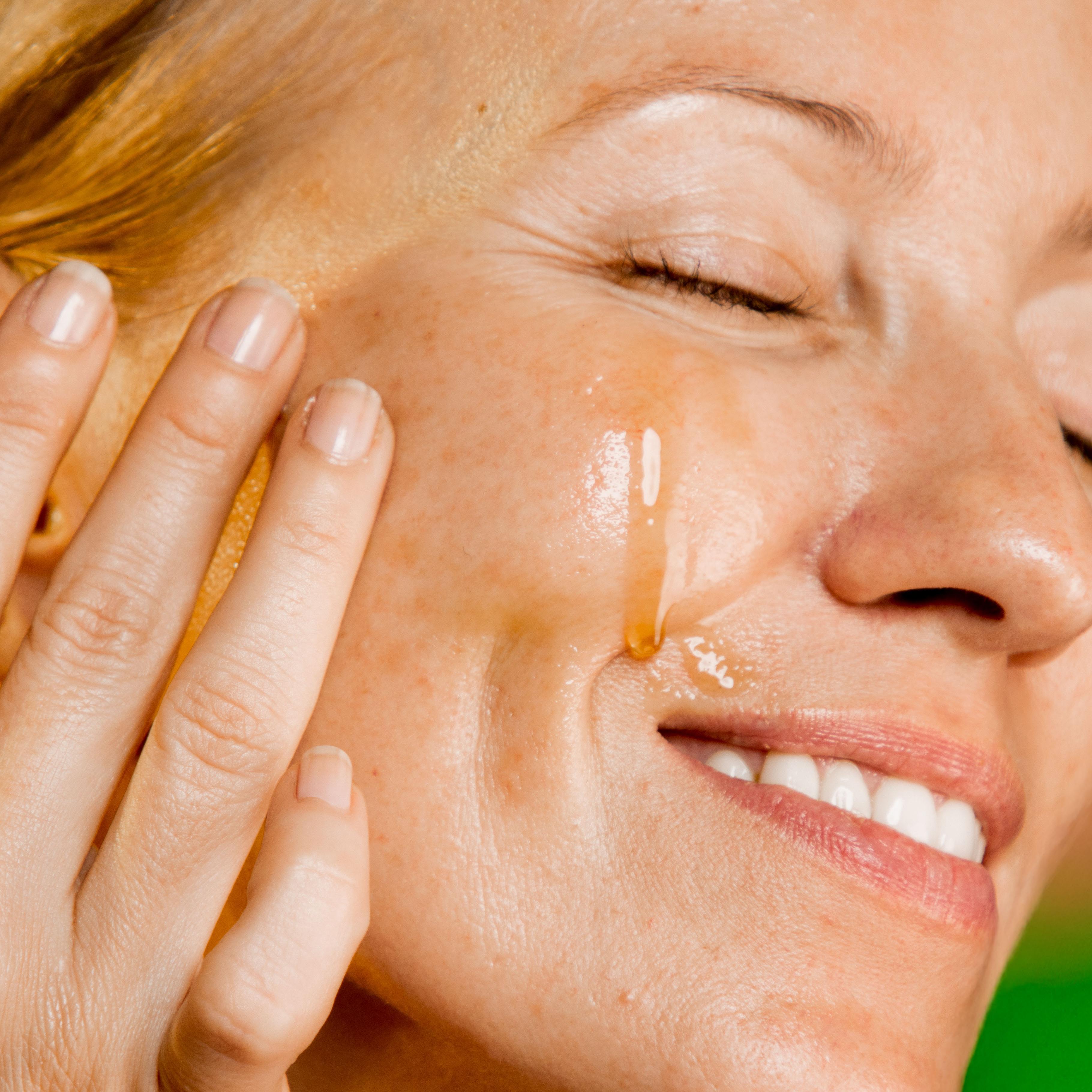 woman applying paraania oil on face