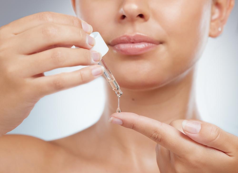 Woman applying retinol serum as the final step of her night skincare routine.