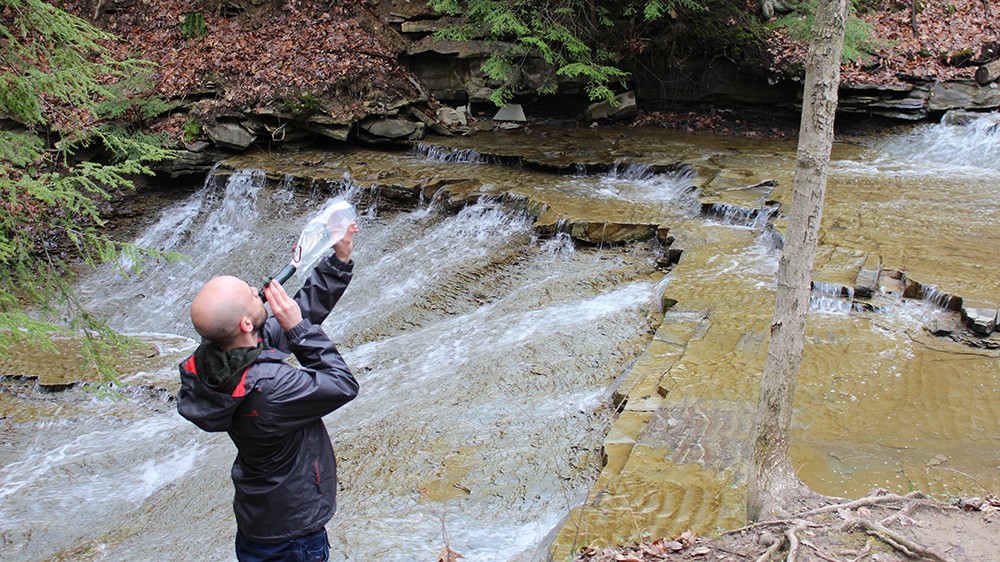 A hiker uses the Survivor Filter Squeeze Kit on a hike through Cuyahoga Valley National Park 
