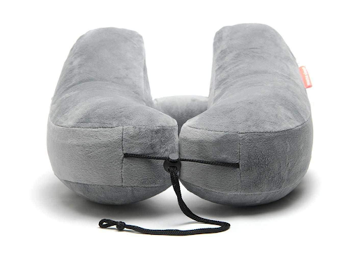 A gray travel pillow covered in microfleece with a black adjustable strap.