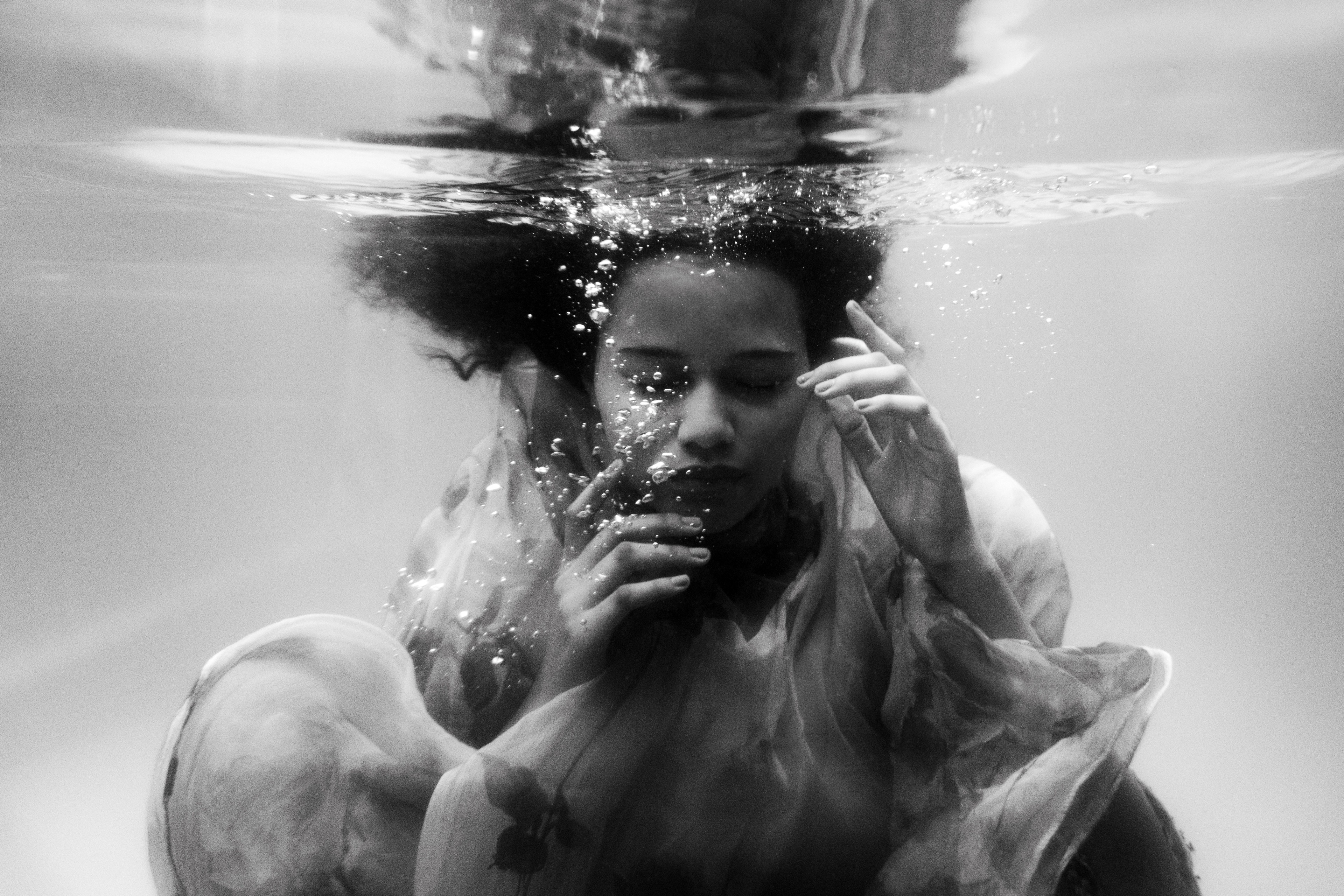 black woman with natural hair swimming underwater