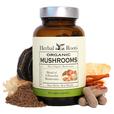 Bottle of Herbal Roots Organic Mushrooms. The bottle is surrounded by a variety of mushrooms. There are a few capsules on the right and powder on the left