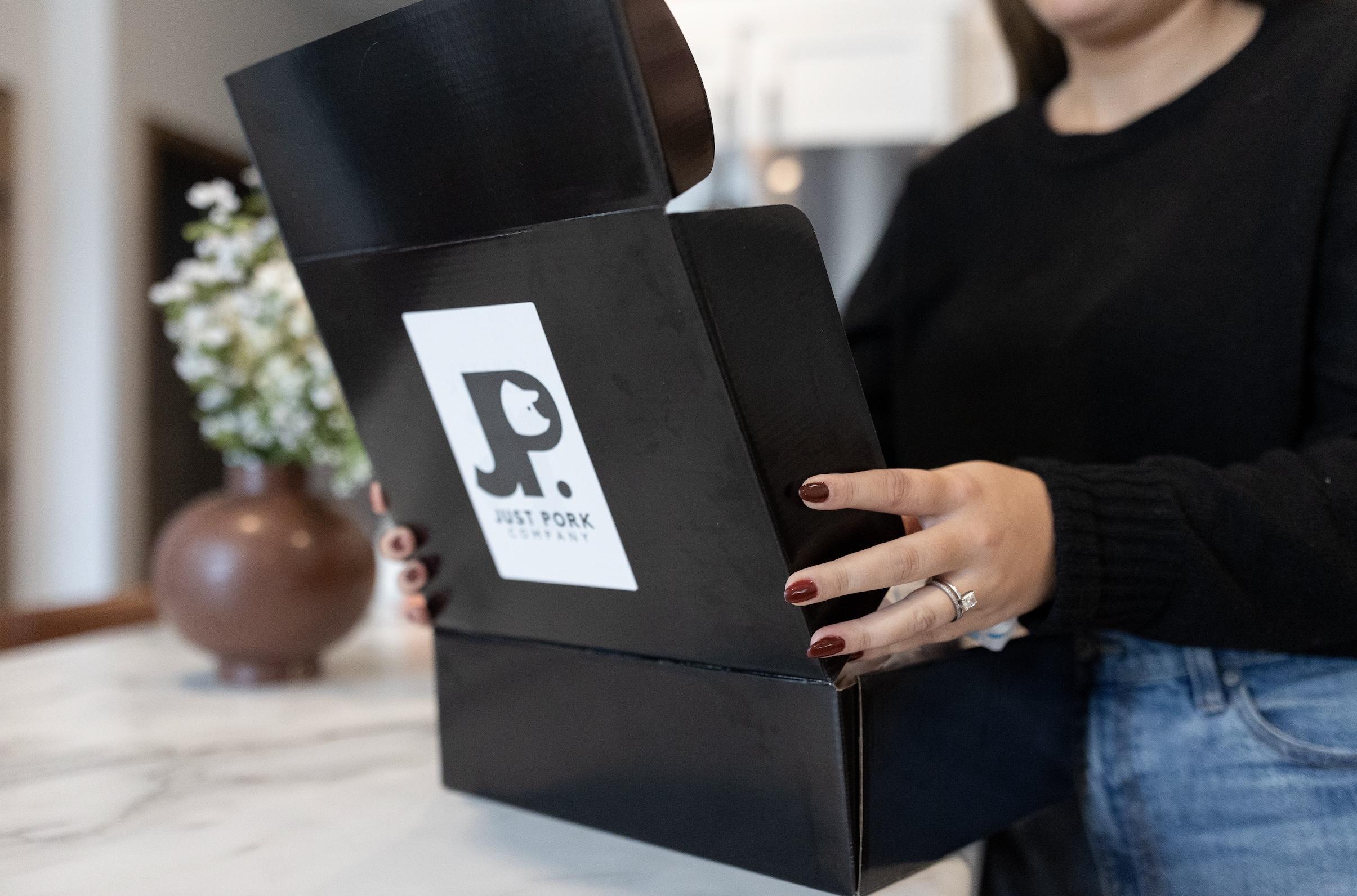 Women opening a pork bundle box
