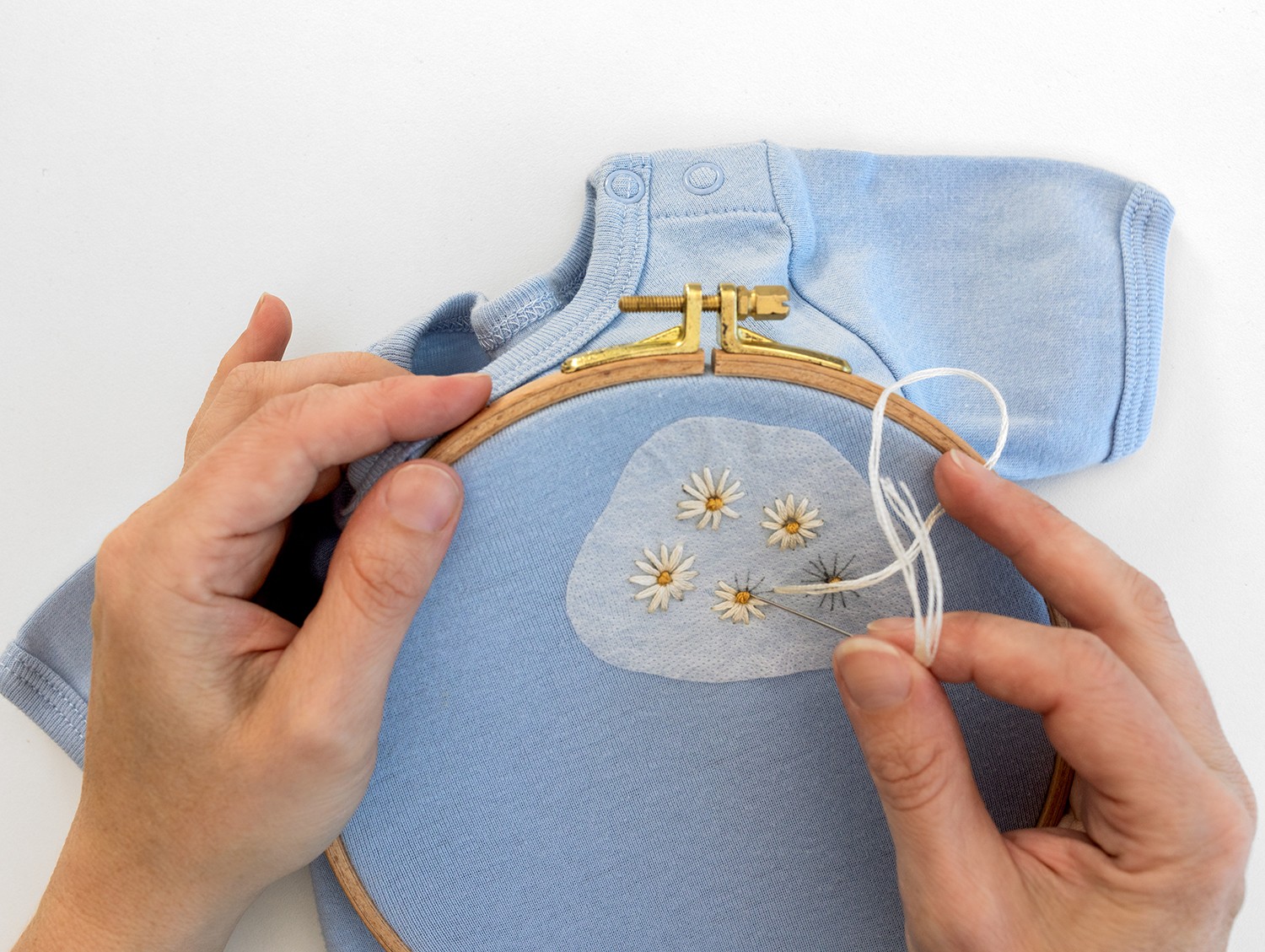 Daisies are sewn in a shirt.