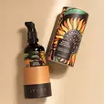 A bottle of Yauvari amplified youth spring surrounded by ingredients like black gram, cut in half limes, neroli flowers with it's buds and leaves.
