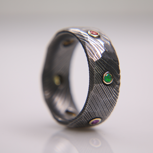 The Obsidian Damascus Infinity Ring is a unique gold bezeled gemstone band and is a perfect option for September birthstone jewelry