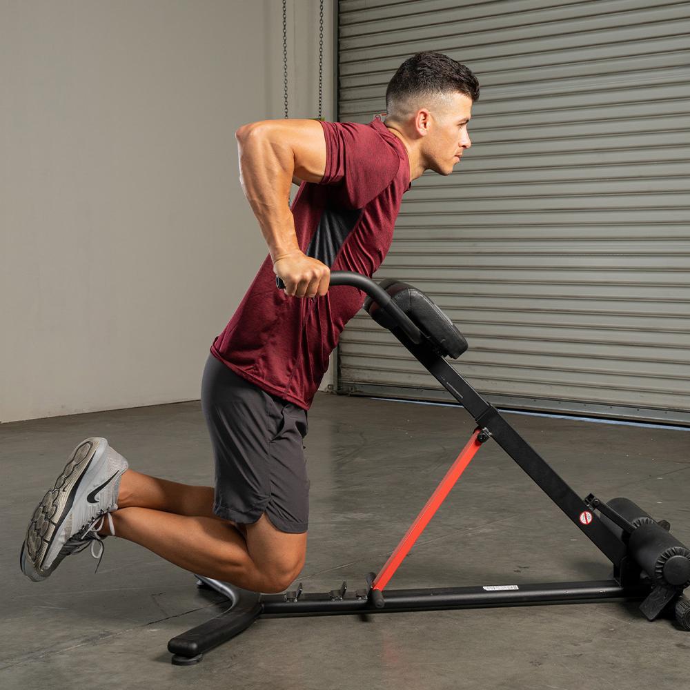 man exercising on a dip station roman chair