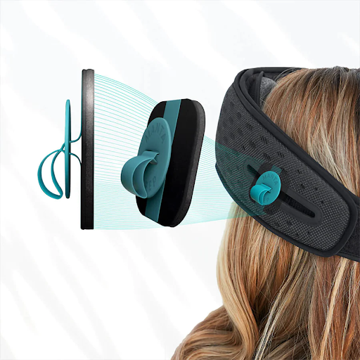 Two thin black speakers with blue tabs and black mesh head strap of a sleep mask with headphones on a girl’s head.