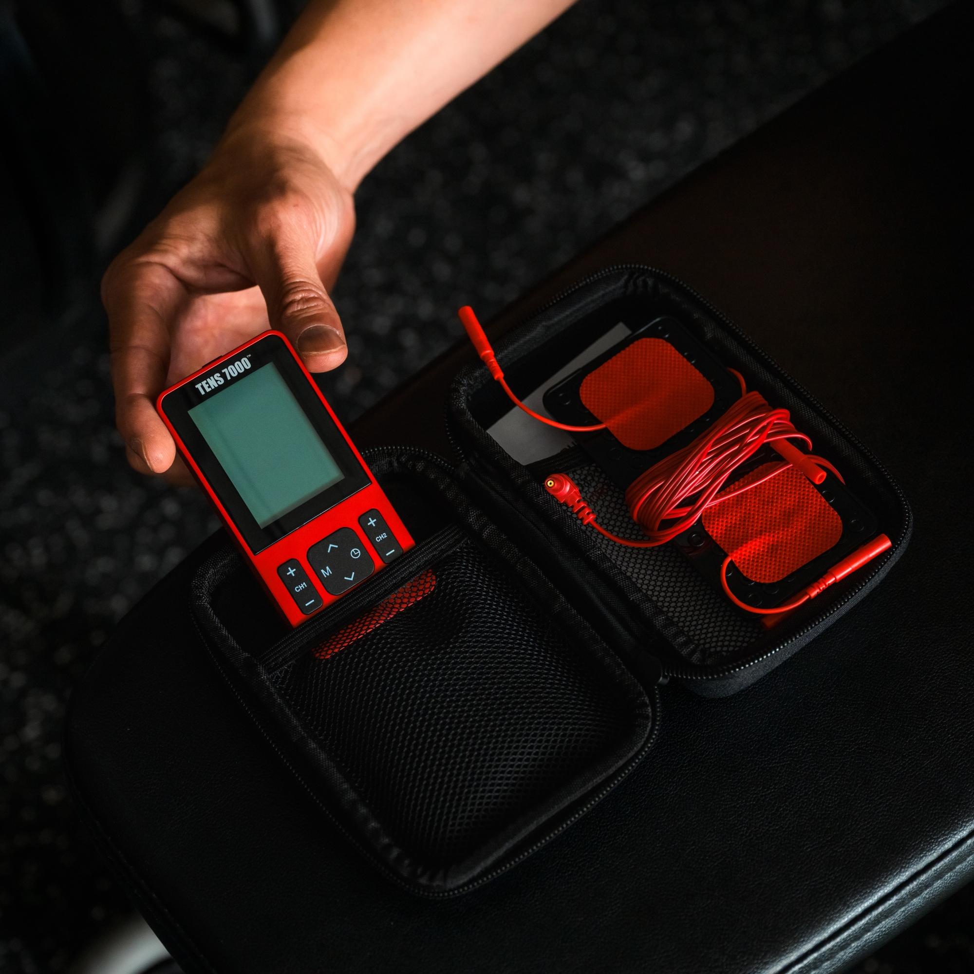 A man's hands pulling out the TENS 7000 Sports TENS Unit out of its carrying case