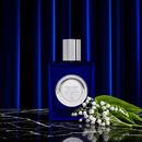 Lily of the Valley bottle with white lily flowers against a pleated curtain