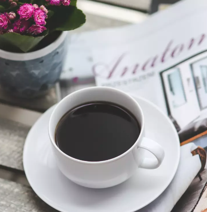 Woman Smiling with a cup of Coffee on her hands