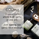 Background image of 5 garlic bulbs with roots on them next to a bottle of Herbal Roots garlic bottle on its side with capsules spilling into a wooden spoon. There is a text box that says 600 mg organic pure whole bulb garlic in one pill. Just eating raw garlic isn't enough.