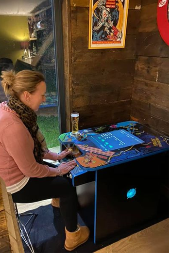Bright multigame retro arcade machine with person playing