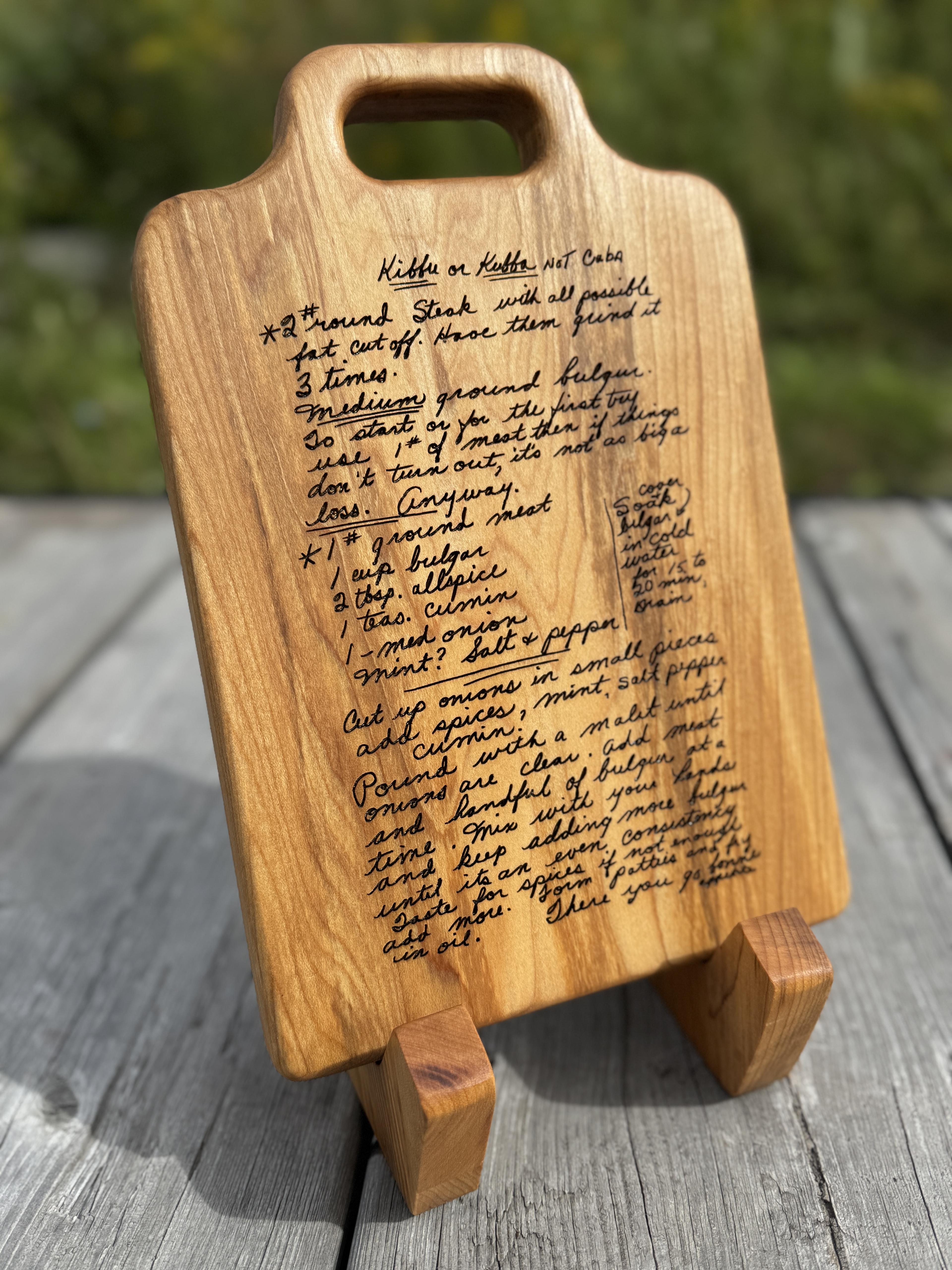 Woman holding a small personalized appetizer plate with a glass of wine and food on it in front of a fire place with a dog next to her.