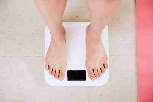 woman standing on scale to weigh in