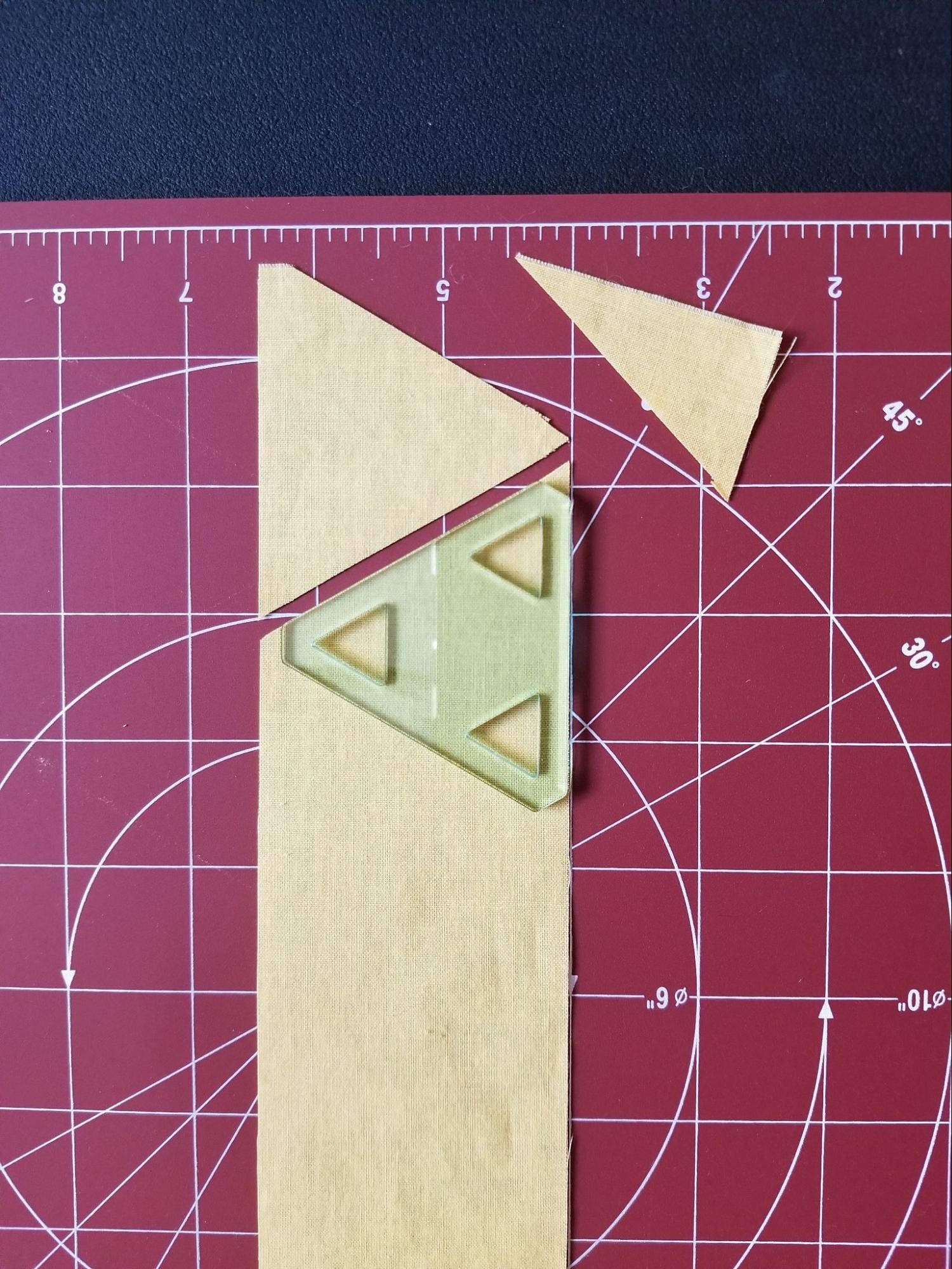 Aligning for the second triangle when strip cutting using a 60 degree triangle quilt template.