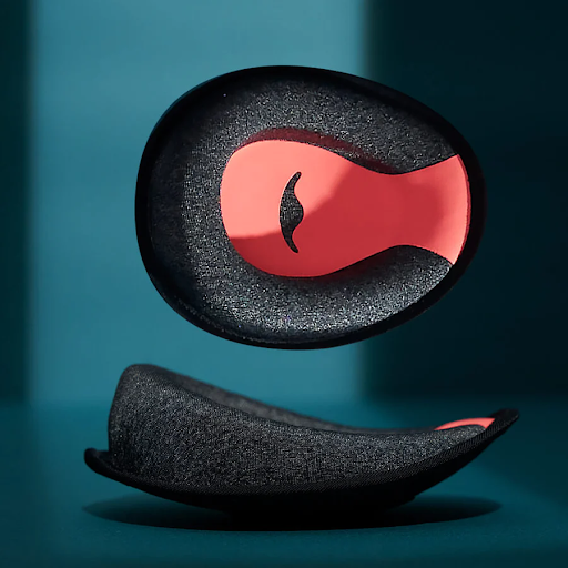 A pair of C-shaped eye cups with an orange interior of a sleep mask with headphones.