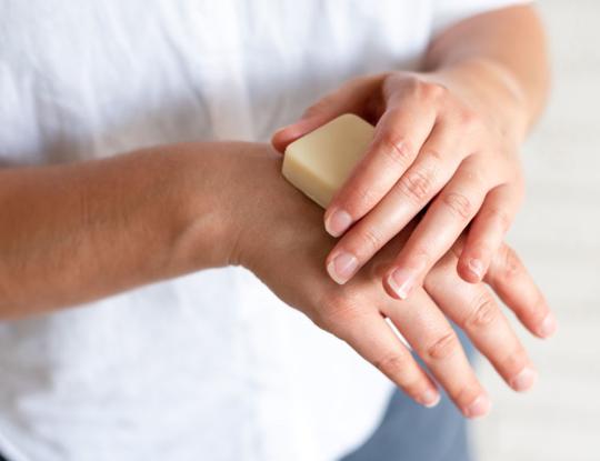 hands holding beesilk hard lotion bar