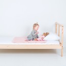 Girl on the bed with a doll and pink PeapodMat