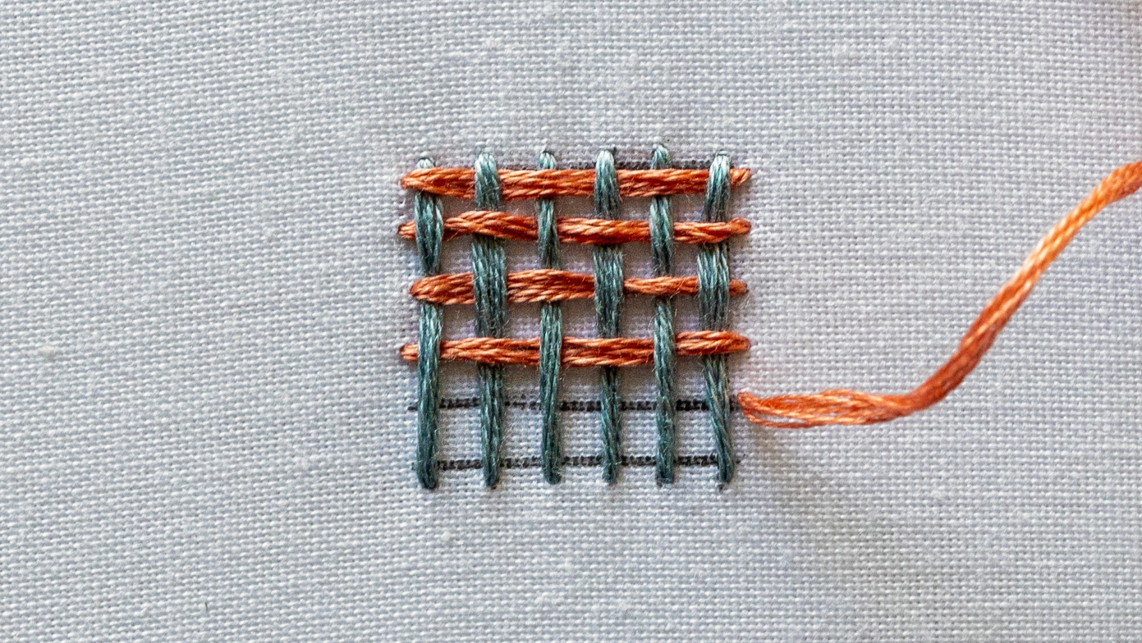 Several rows of weave stitch building up to fill a shape.