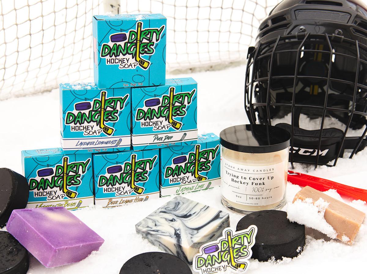 dirty dangles soap, candle and accessories on a snowy background with hockey gear