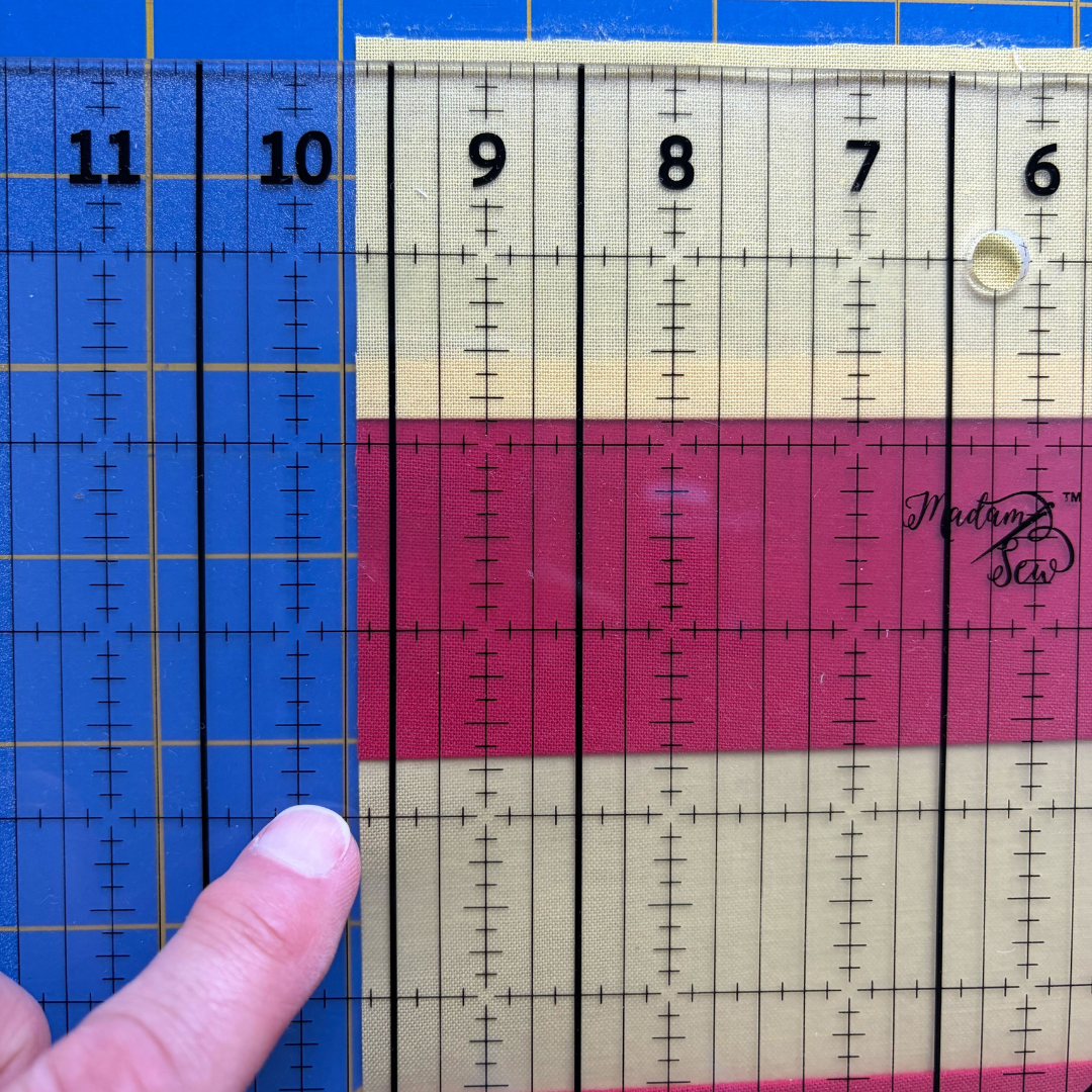Madam Sew 12.5” Square-Up Ruler on top of a quilt block where the block edge is a little past the 9.5” bold vertical guideline.