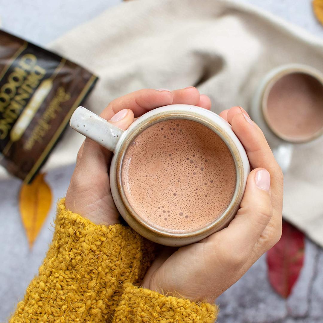 two hands holding cup of hot drinking chocolate