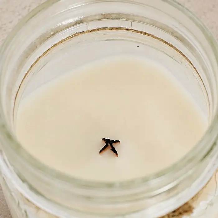 candle's wooden wick properly trimmed by wick trimmer