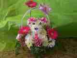 A picnic basket decorated in flowers that look like a bear