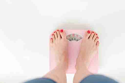 woman standing on scale for weightloss