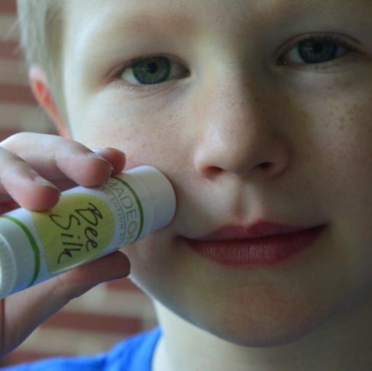 boy applying beesilk lotion stick to face