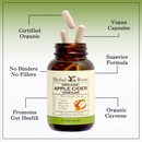 Bottle of Herbal Roots Organic Apple Cider Vinegar with three pills spilling out of the top of the bottle. There are several lines pointing to the bottle and the capsules. The lines say Certified Organic, Vegan Capsules, Superior Formula, No Binders or fillers, Promotes Gut health and organic cayenne.