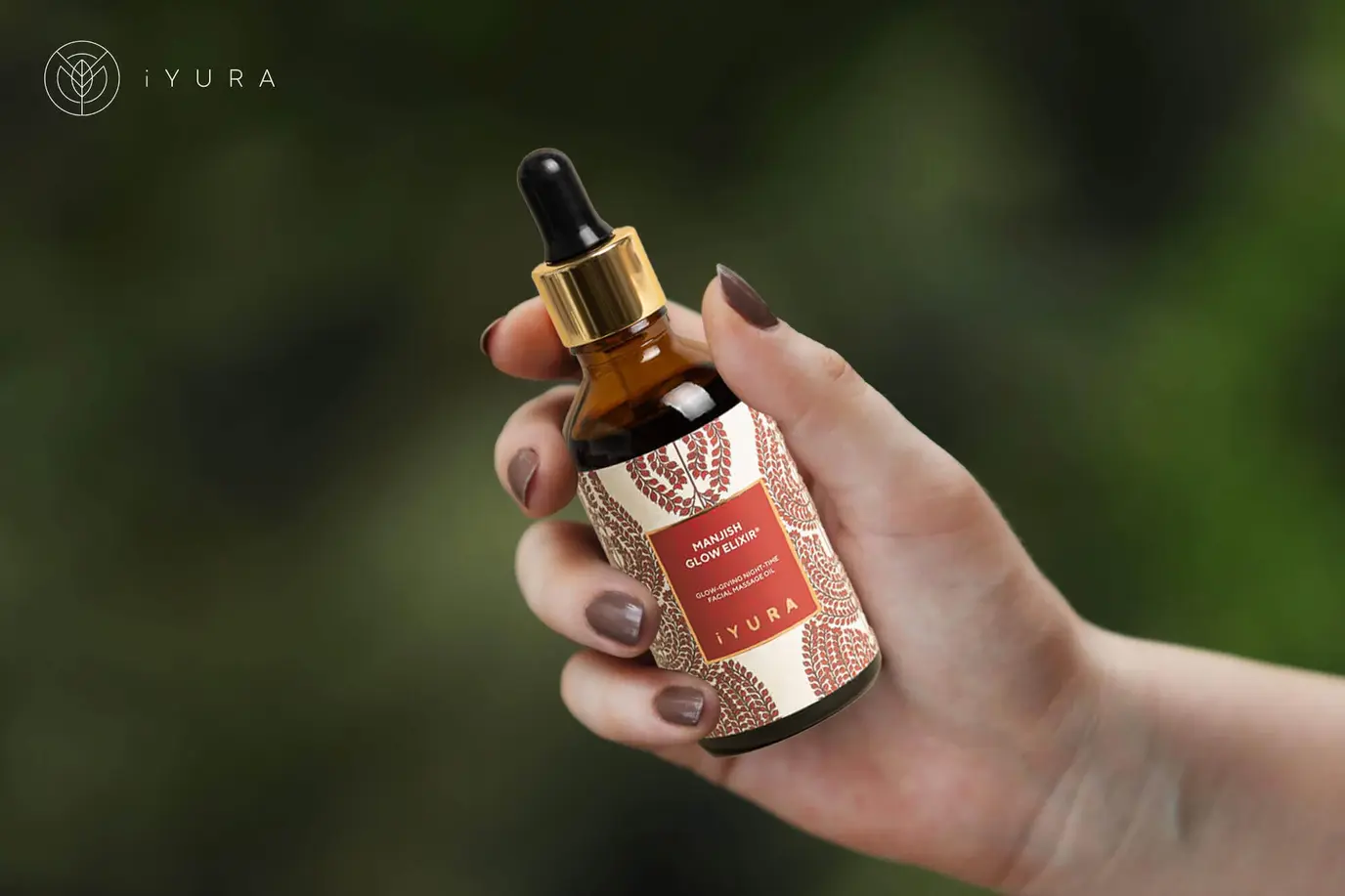 A hand holding Manjish Glow Elixir: 4 drops, 5 minutes every night for a natural, no-makeup glow