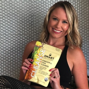A woman holding up a gusset bag of Pineapple Chia Cleanse.