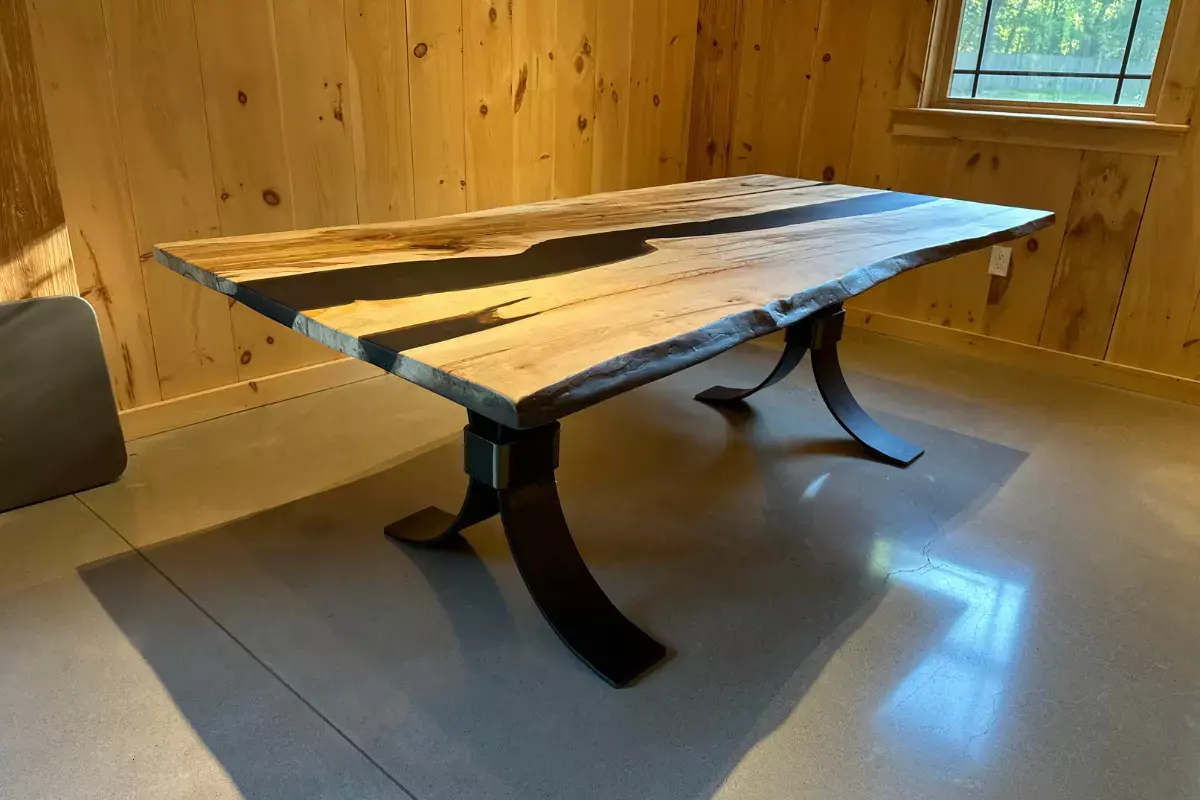 Live edge wormy maple dining table with sculptural steel base