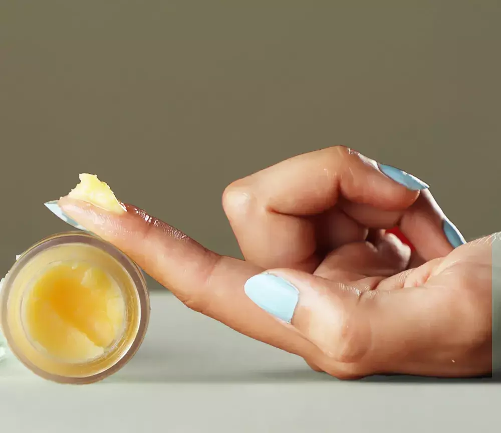 woman taking out Sandalwood Rose Age- Defying Eye Butter