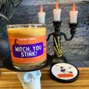 An orange witch you stink stank away halloween candle on a spooky halloween background