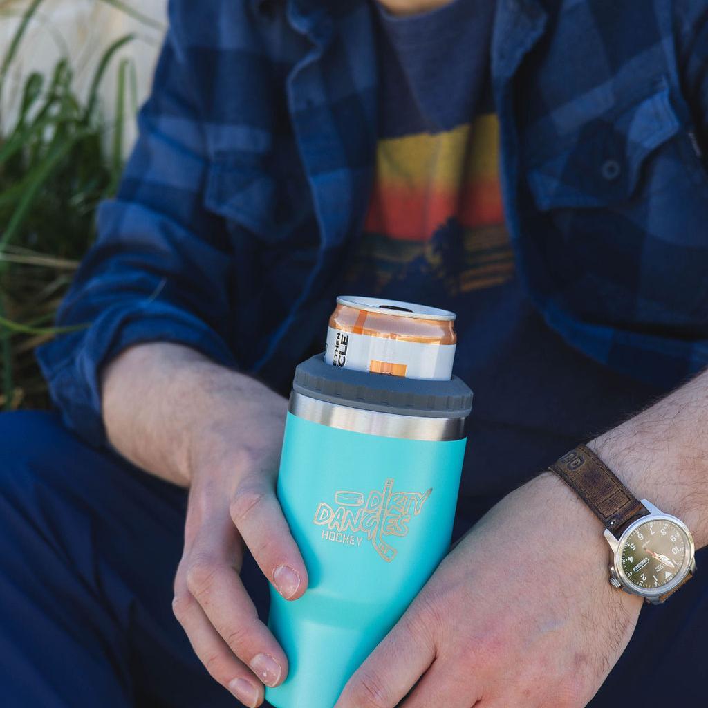 A man holding a blue dirty dangles 2 in 1 drink tumbler can cooler outside.