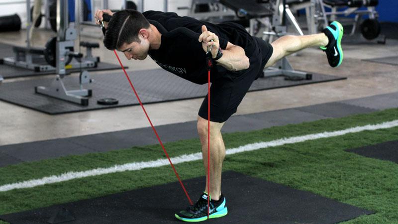 man using xbar resistance band inside lower body workout