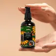 A person holding a bottle of Balaayah Black Gram Body Booster - Tea Garden Blend