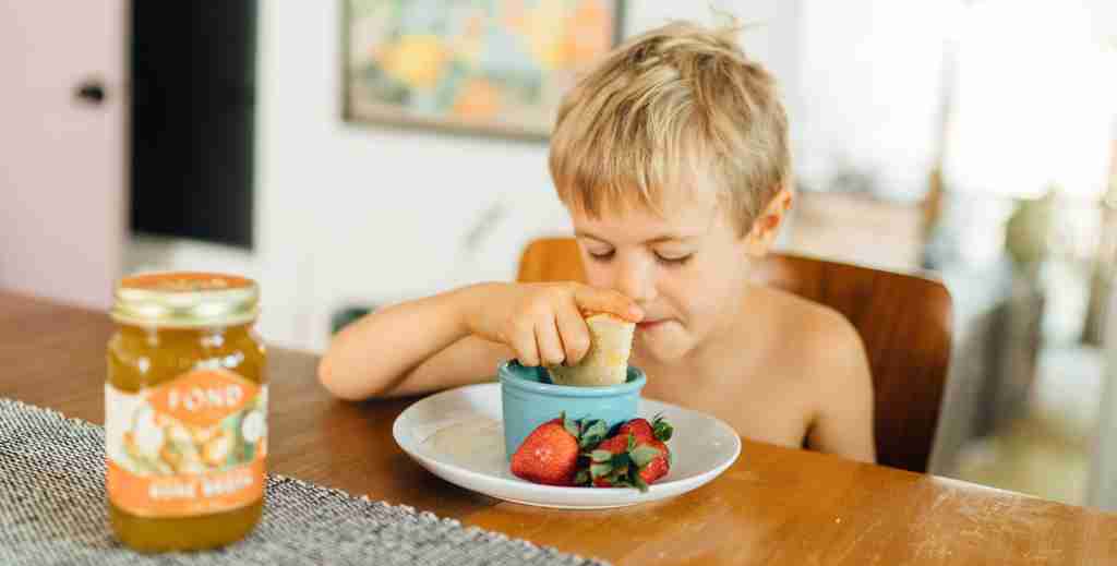 Young boy eating tomato soup and grilled cheese made with FOND bone broth