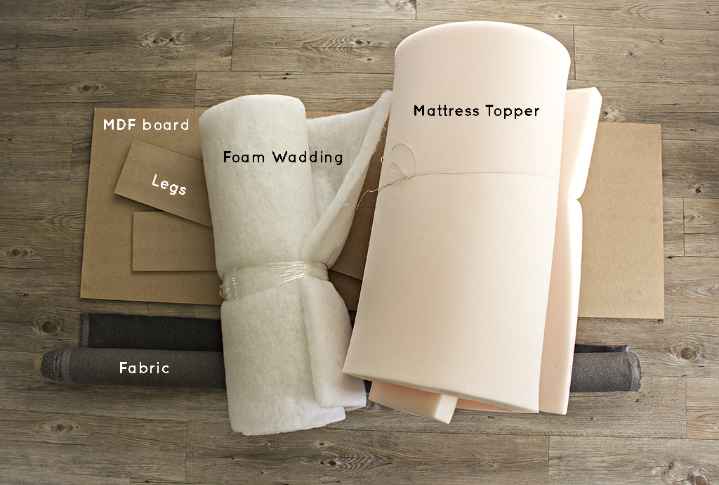 This is an image of the supplies used for an upholstered headboard - including the MDF board, legs, fabric, foam wadding, and mattress topper.