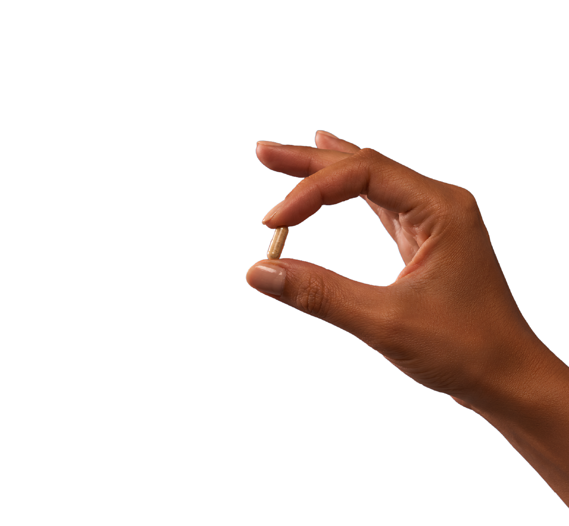 Hand holding a capsule of Raw Desiccated Thyroid
