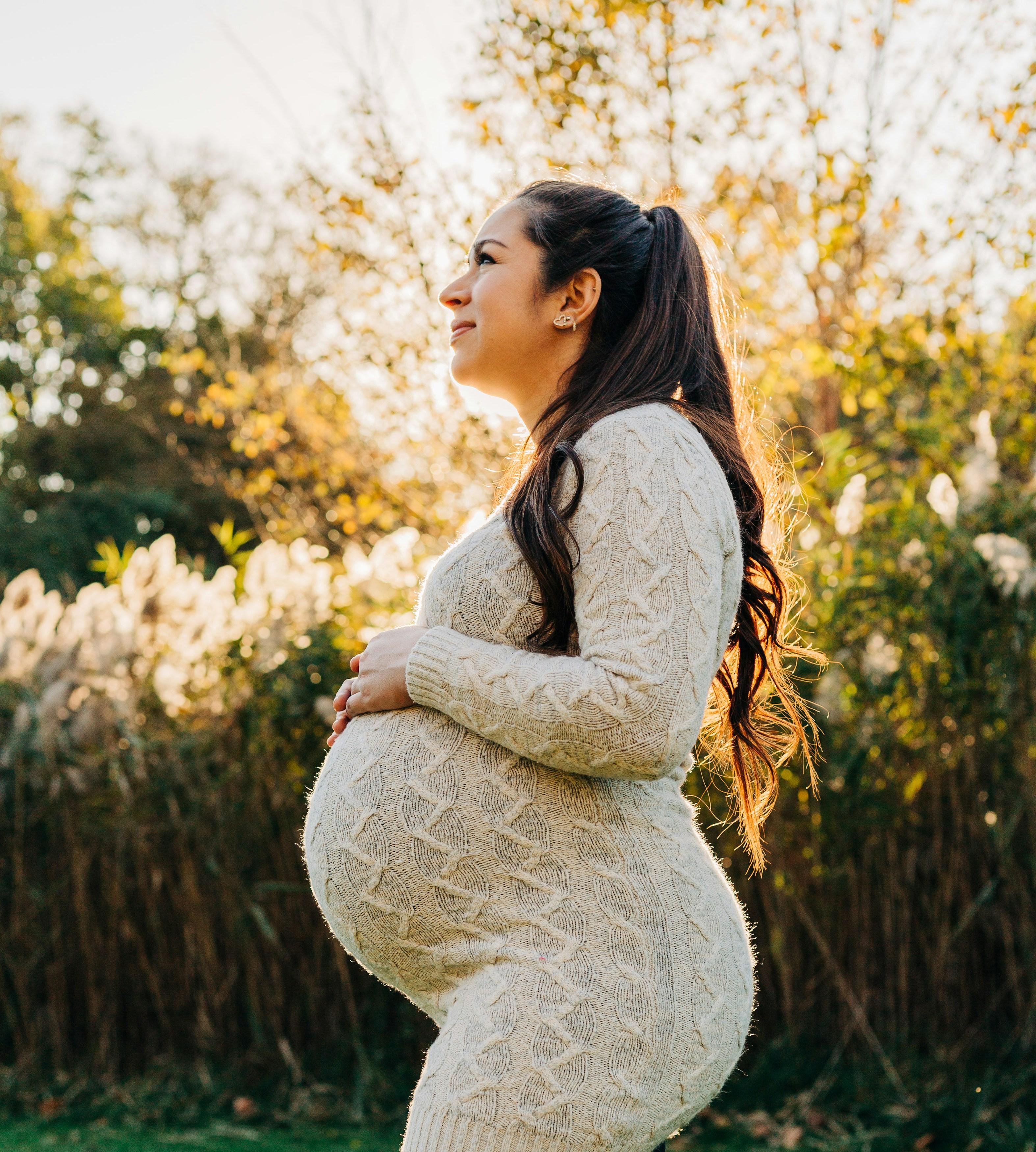 A happily pregnant woman increasing her progesterone naturally by receiving Vitamin D from the sun.