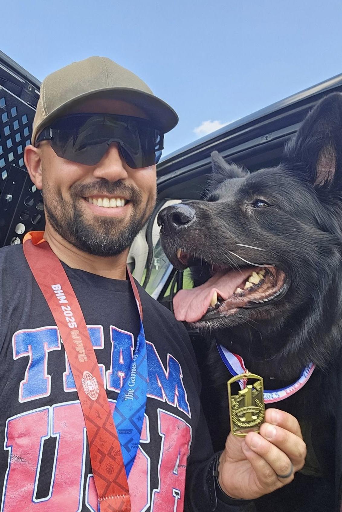 bear and his handler with gold medal