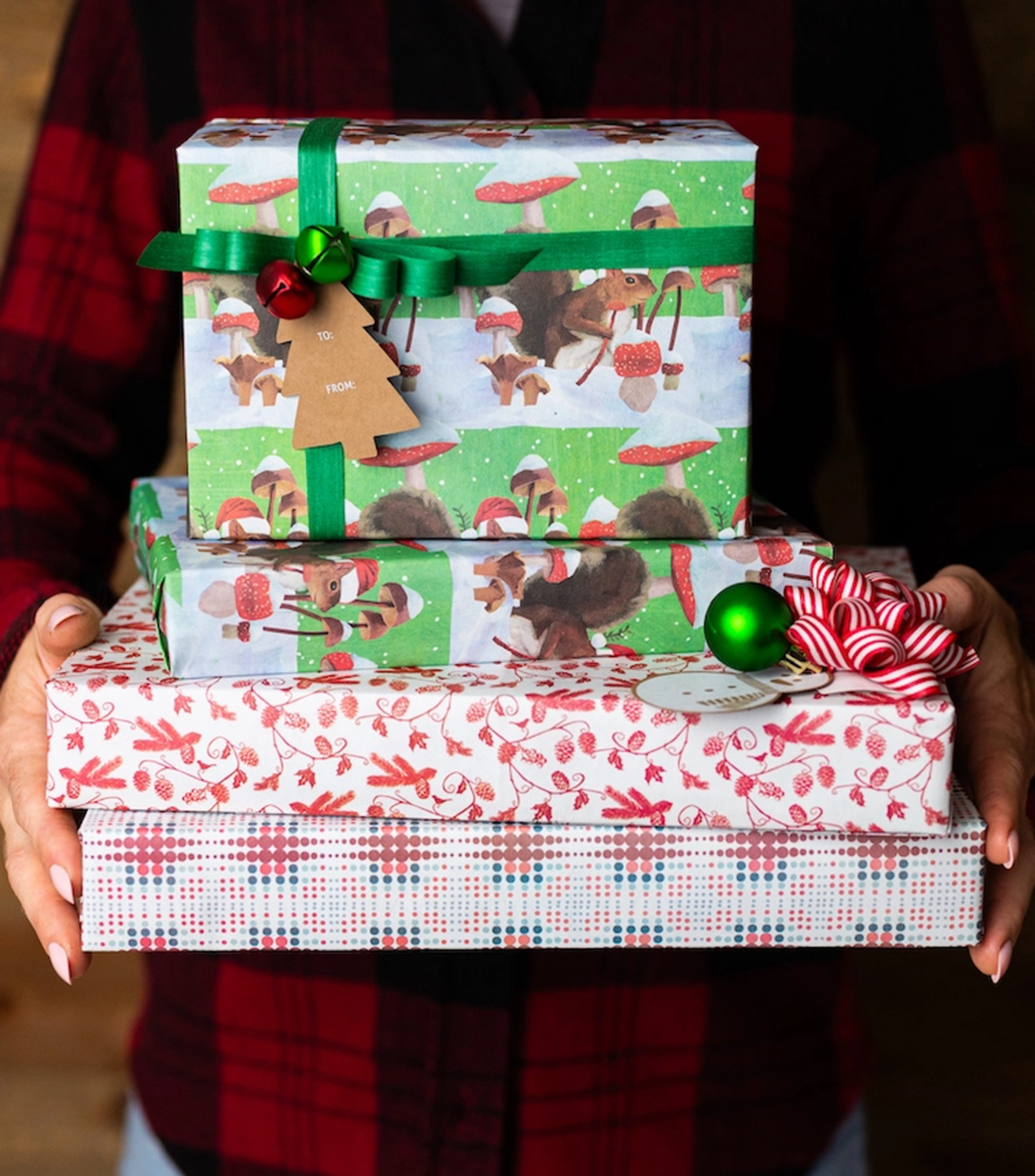 someone holding four wrapped gifts with Wrappily eco friendly wrapping paper