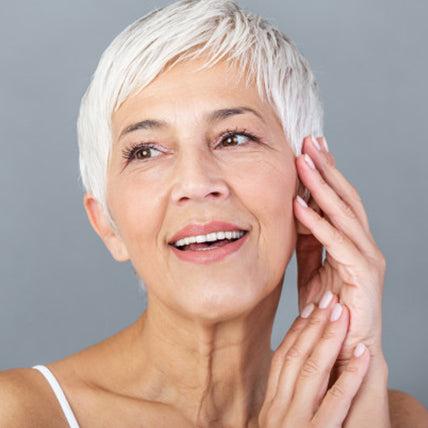 Smiling mature woman touching her cheek
