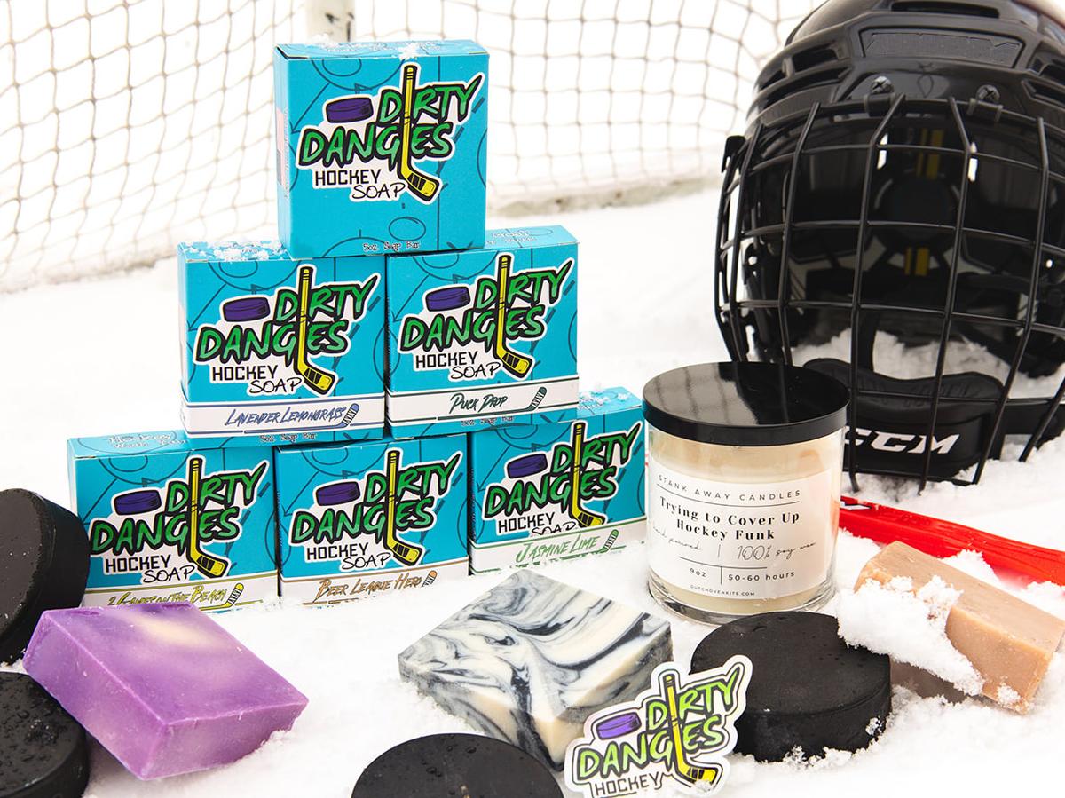 dirty dangles soap, candle and accessories on a snowy background with hockey gear