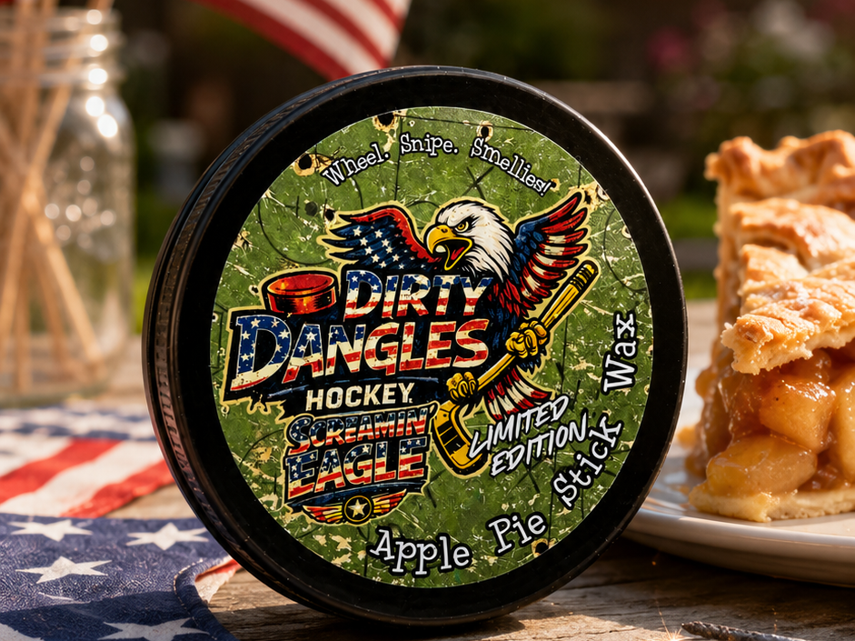A tin of dirty dangles screamin eagle 4th of july stick wax on a picnic table with apple pie and american flags